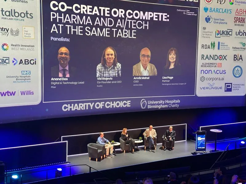 Panel participants seated beneath the Co-create or Compete session screen at Life Sciences Week.